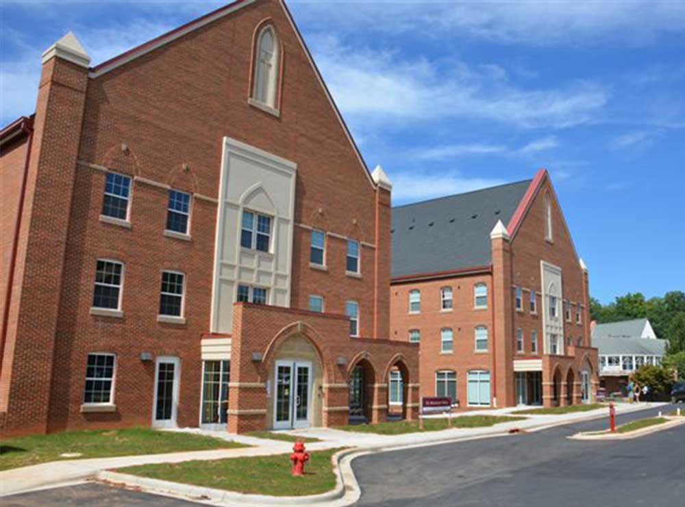 Two large brick buildings with blue sky in background.