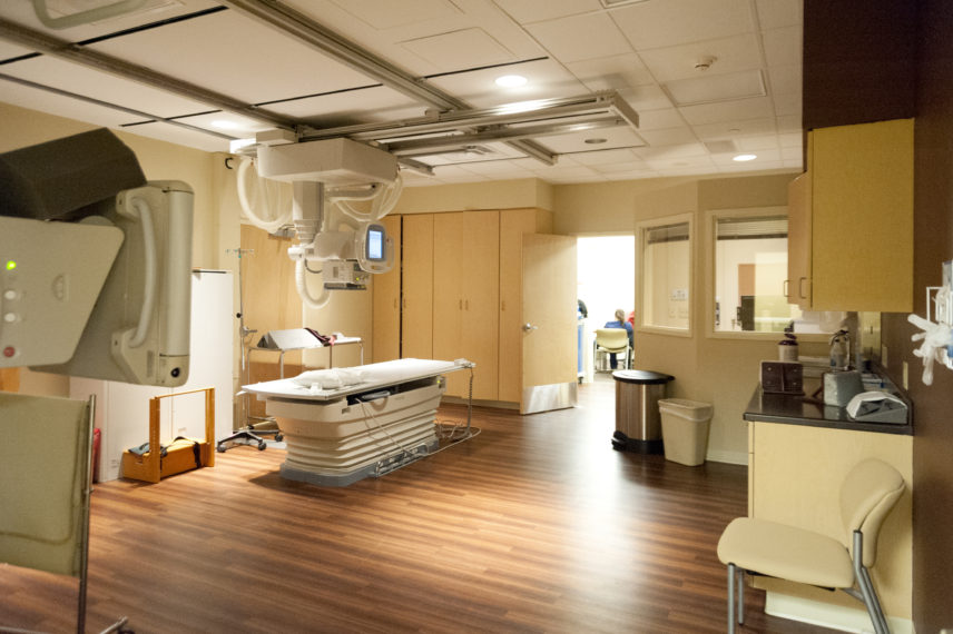 Hospital x-ray room with equipment and wood floor in hospital.