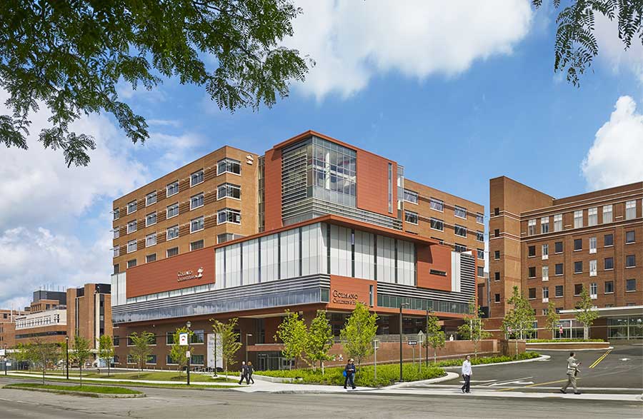 Modern large brick hospital with glass windows.