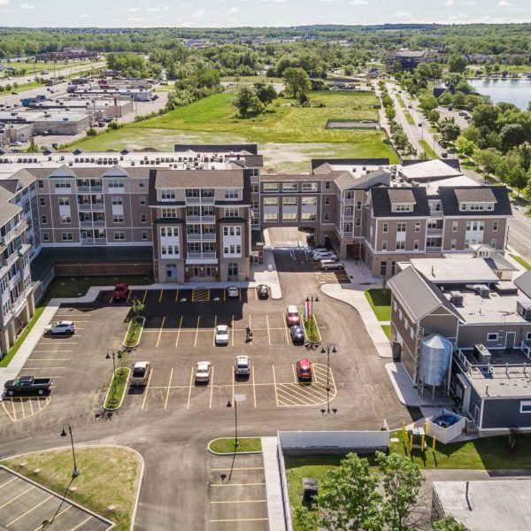 Aerial of three multi-unit housing buildings with the shore to the right.