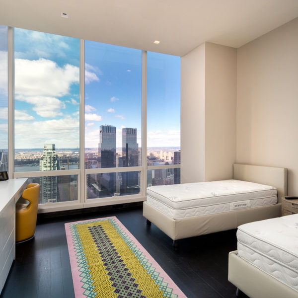 Bedroom with two beds overlooking city skyline