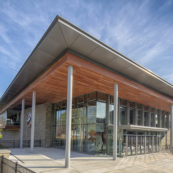 Exterior of the building showing glass and wood facade on a sunny day.