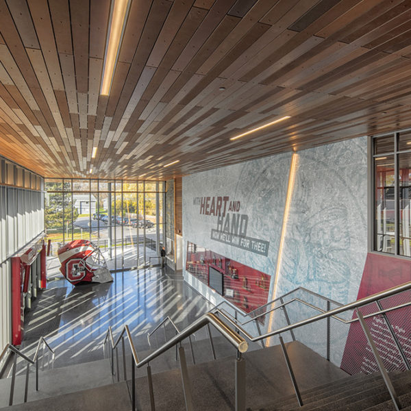 View from top of the stairs looking down into lobby where their is a large Colgate hockey helmet.