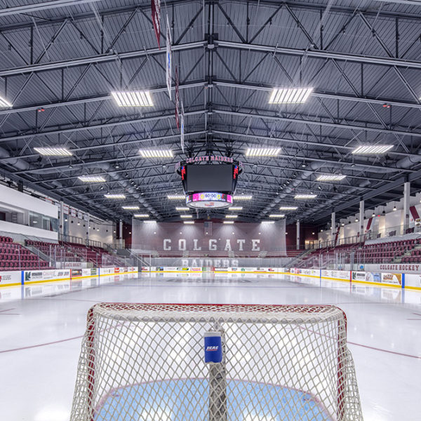 View from behind the hockey net facing the other end of rink with open seats on either side