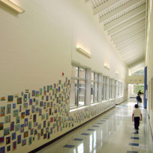 Hallway with photos on the wall and child walking in the hall.