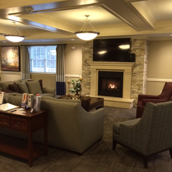 Lounge area with chairs, couches and a fireplace.