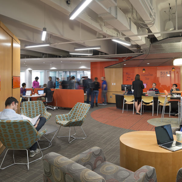 Meeting space with tables and chairs and students.