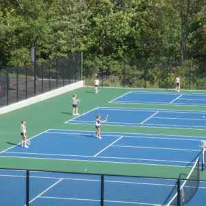 Four tennis courts with tennis players