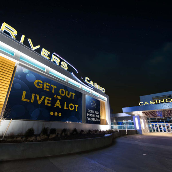 Large casino screens and entrance lit up at night.