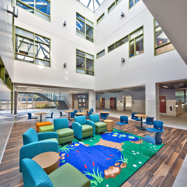 Brightly colored chairs and carpet on the main level with hallways above