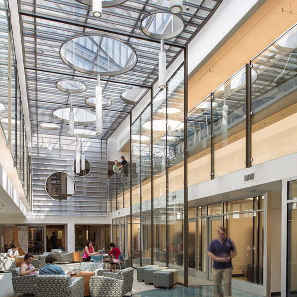 Main floor of building with chairs, students and architectural ceiling.