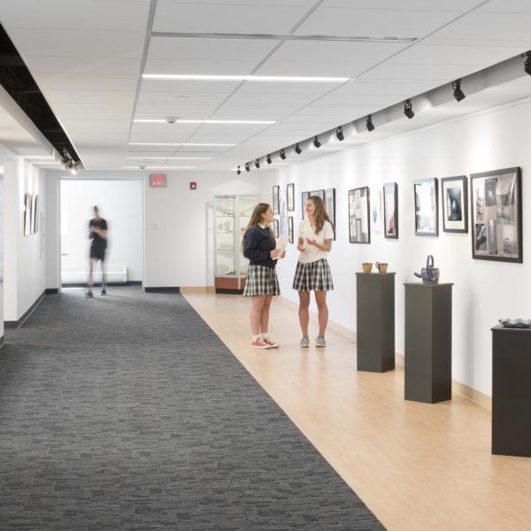 Gallery space with artwork to the right and students