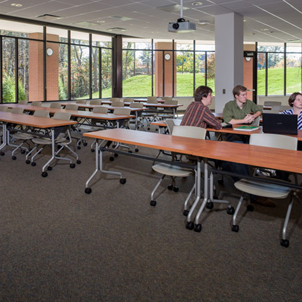 Classroom space with tables, chairs and students