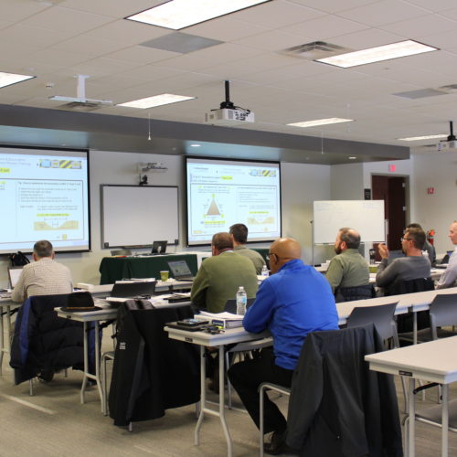 Group of people in meeting room listing to presentation.