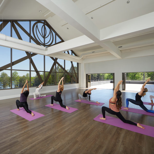 Grand yoga hall with people on yoga mats