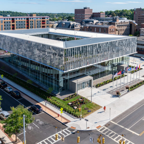 Photo of Flag Raising Ceremony at the  NVRC National Veterans Resource Center Syracuse University. This is an exterior photo of the Veterans Resource Center from the roof of Crouse Hinds Hall.