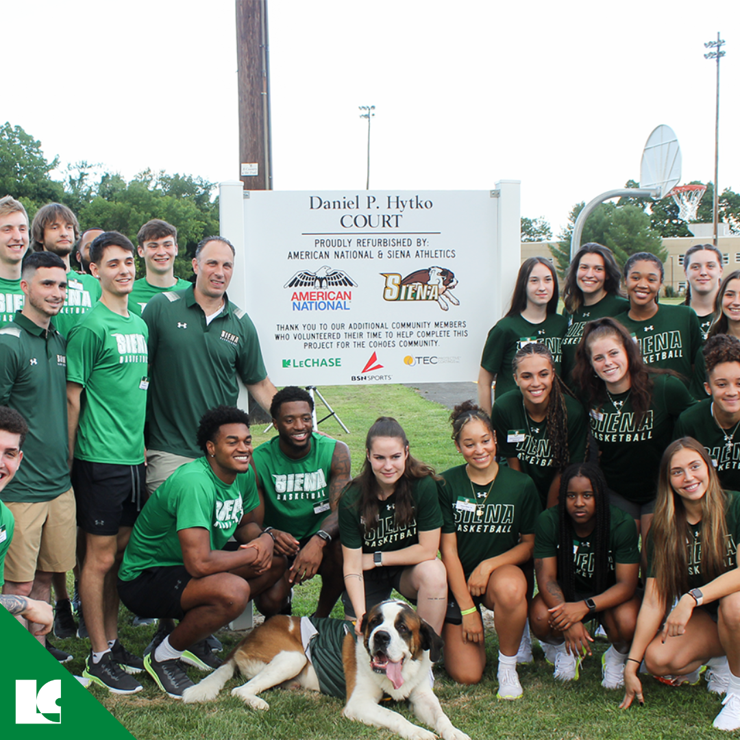 Siena College basketball teams pose with mascot Baloo in front of the new sign at the Daniel P. Hytko Court.