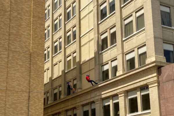 The team rappelling down the building