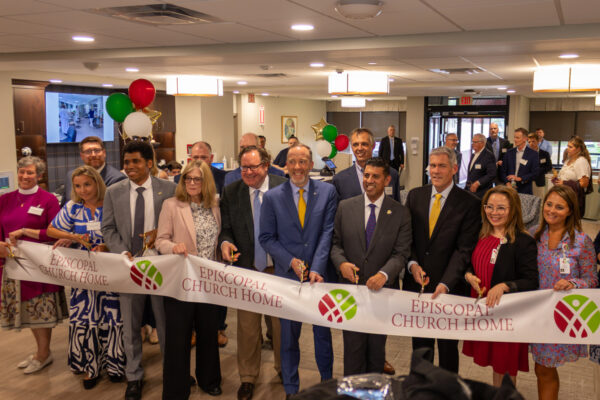 Team cutting the ribbon for the Episcopal Church Home project